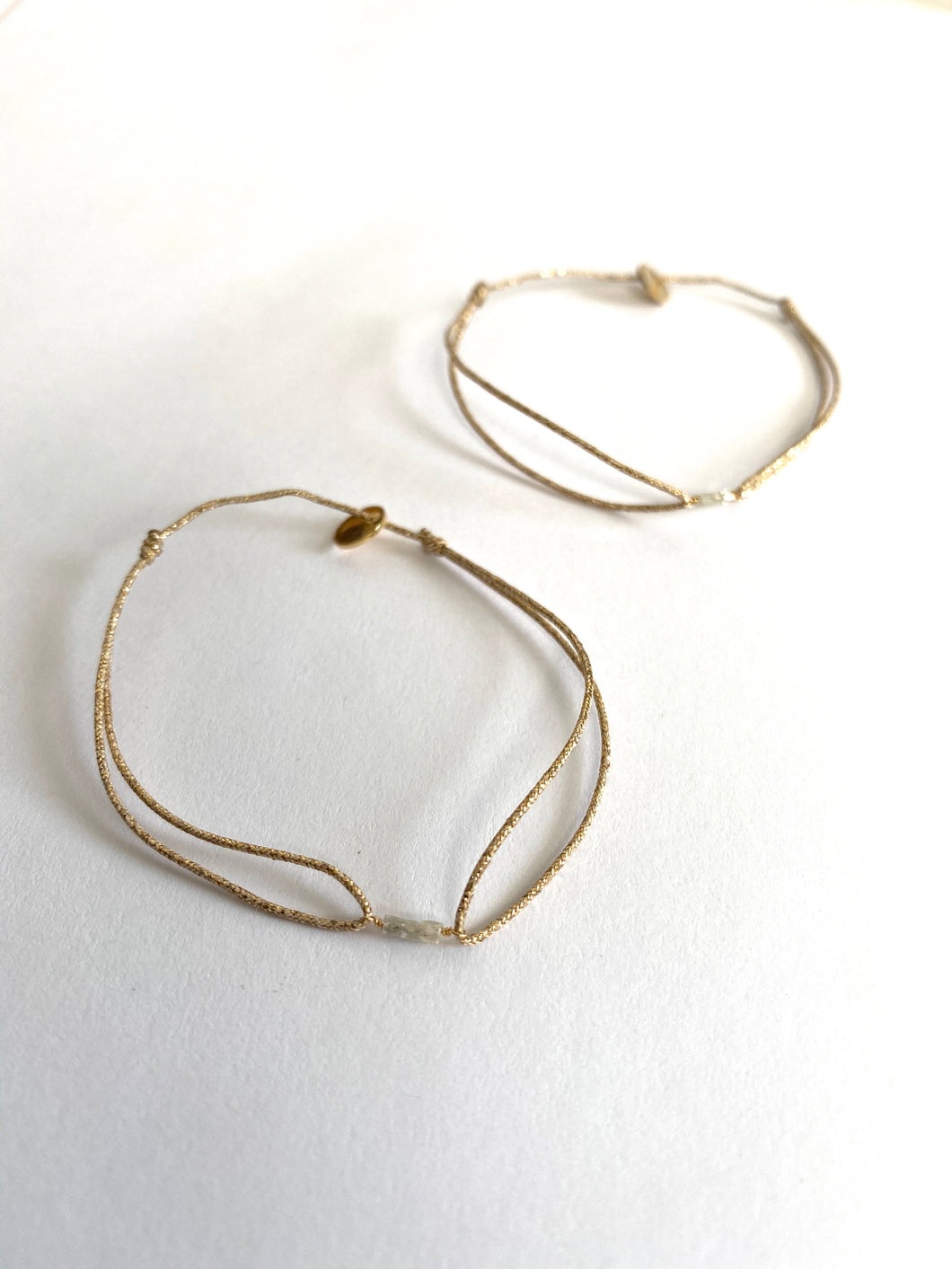 Three raw diamonds on lurex string